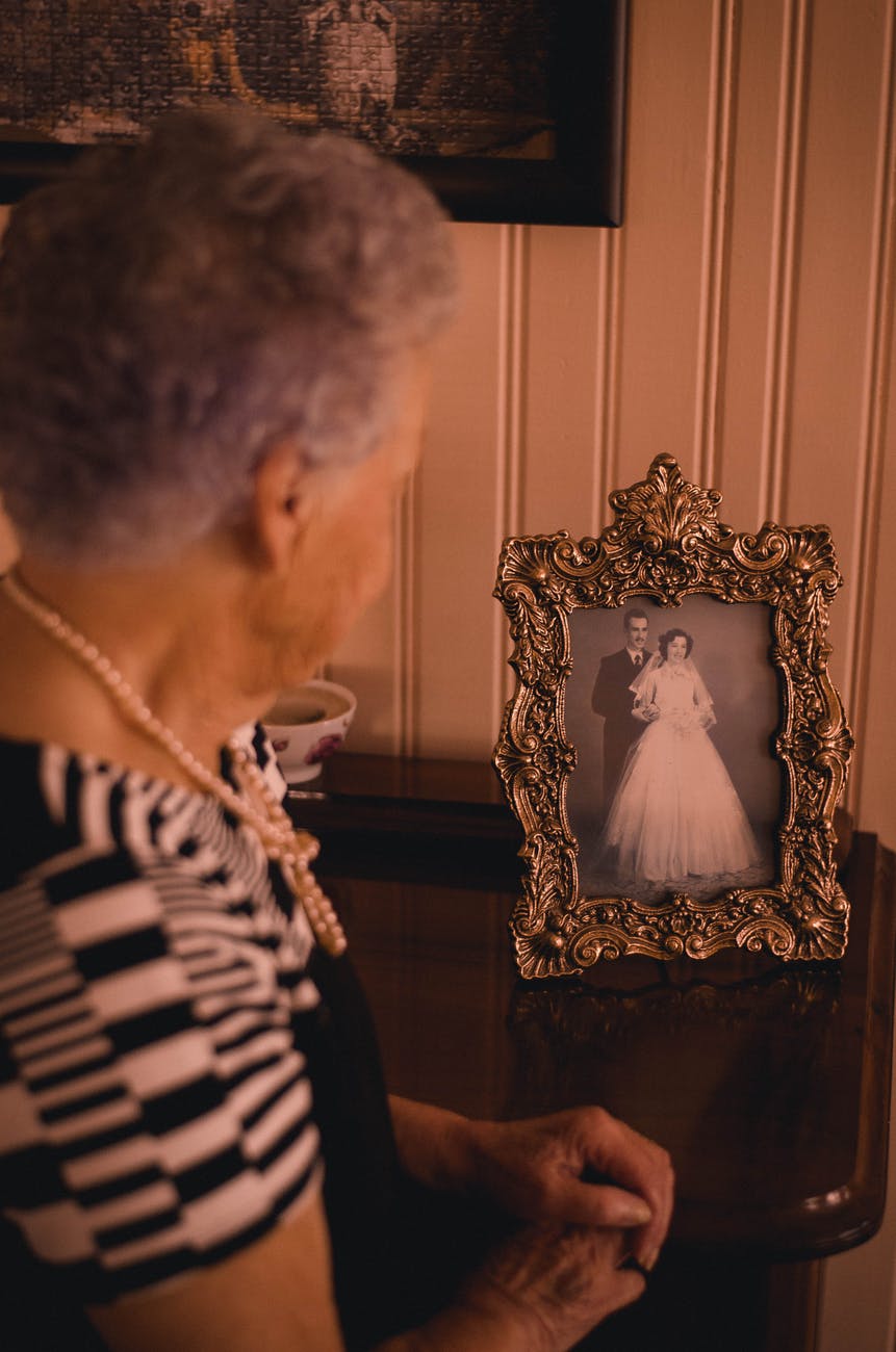 woman standing near photo frame with newly wed couple picture