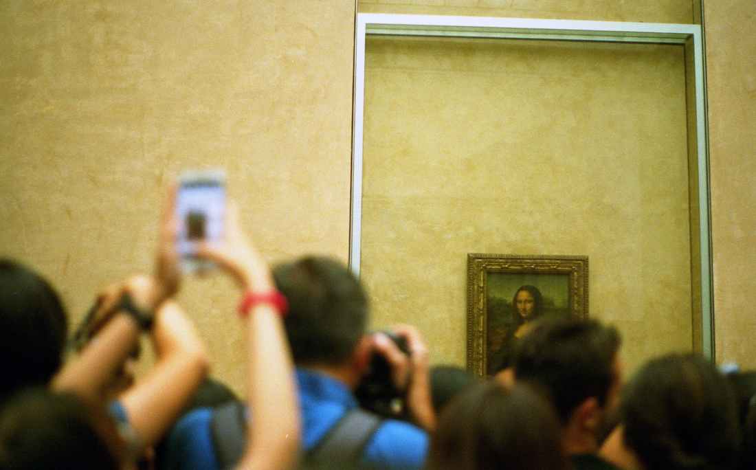 selective focus photo of group of people taking picture of mona lisa painting